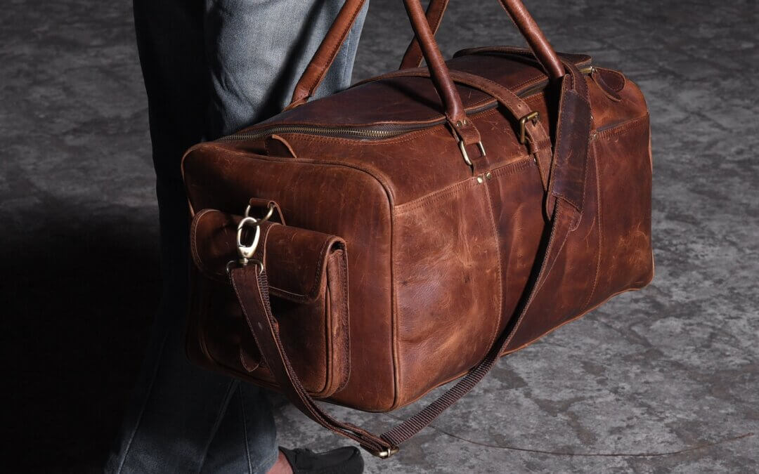 Man walking with a leather travel bag